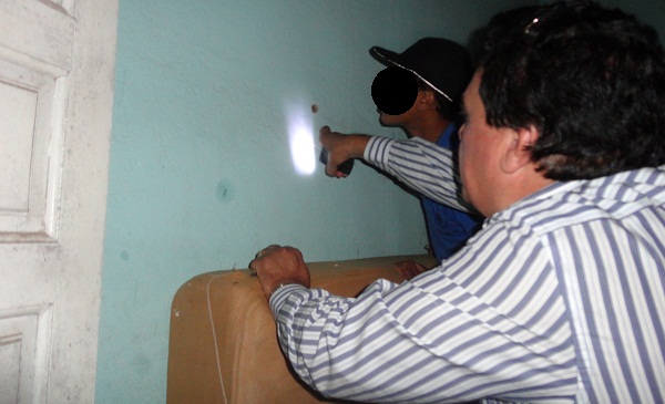 Delegado Marco Antonio Neves confere marca dos disparos na parede