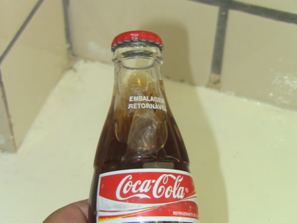 Garrafa de Coca Cola com saco e papel do jogo do bicho 3