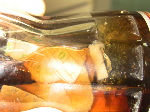 Garrafa de Coca Cola com saco e papel do jogo do bicho